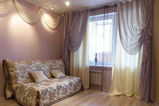 Диван-кровать и окно оформленное текстилем